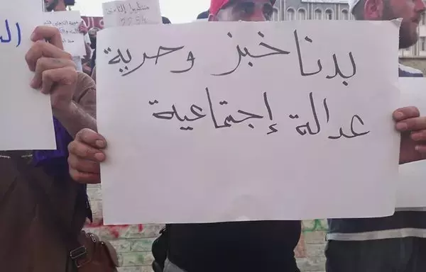 A sign raised in al-Suwayda reads, "We want bread, freedom and social justice," in protest against the country's difficult economic conditions, on August 21. [suwayda24.com]