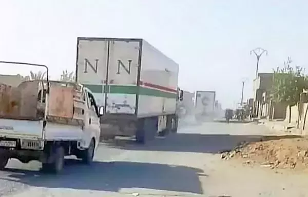 A convoy of trucks carrying smuggled Iranian weapons enters Syria from Iraq through the al-Hari village border crossing, according to Euphrates Eye Network. The network posted this photo on January 23. [Euphrates Eye Network]