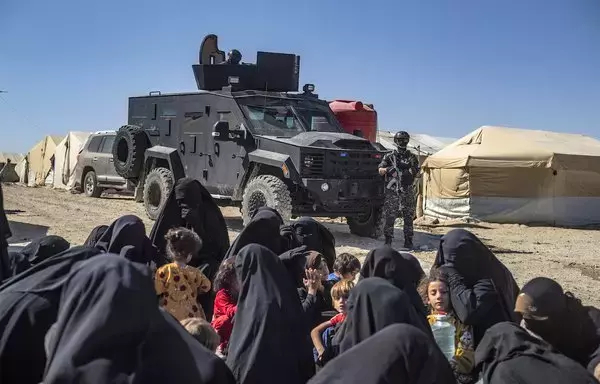 A member of the Syrian Kurdish security forces (Asayesh) stands guard during an inspection of tents at al-Hol camp, which holds relatives of suspected ISIS fighters in the northeastern al-Hasakeh province, on August 28, 2022, as the Syrian Democratic Forces mount a security campaign against ISIS 'sleeper cells' in the camp. [Delil Souleiman/AFP]