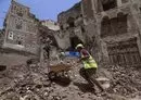 
A worker removes the rubble to prepare for restoration on the site of a collapsed UNESCO-listed building following heavy rains, in the old city of Sanaa, on August 12, 2020. [Mohammed Huwais/AFP]        