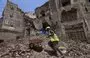 
A worker removes the rubble to prepare for restoration on the site of a collapsed UNESCO-listed building following heavy rains, in the old city of Sanaa, on August 12, 2020. [Mohammed Huwais/AFP]        