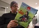 
A man holds a copy of Iranian magazine Sazandegi reporting on the death of Mahsa Amini, a woman who died after being arrested by the Islamic Republic's 'morality police,' in Tehran on March 14. [Atta Kenare/AFP]        