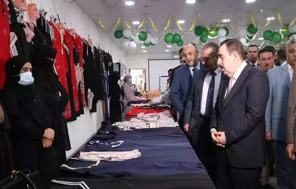 Iraqi officials on August 20 view abayas sewn by women who returned from displacement camps in Anbar province. [Iraqi Ministry of Migration and Displacement]