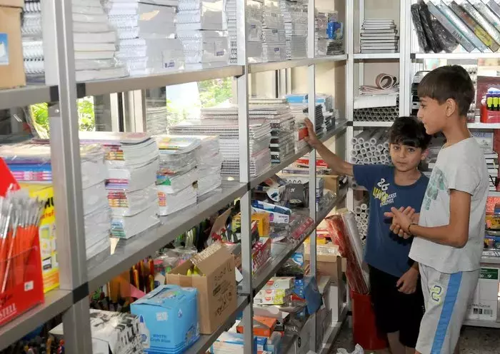 Two Lebanese students peruse the shelves of a textbook and stationery store. [Naji Akram/Al-Fassel]