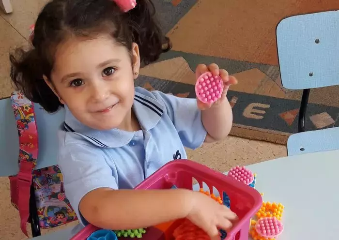 A girl plays with plastic toys in a classroom in Lebanon, at a time when many are concerned about school closures. [Naji Akram/Al-Fassel]