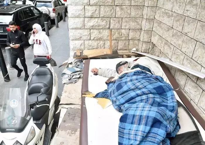 A man sleeps on a sidewalk in Beirut. Extreme poverty has left many Lebanese without shelter. [Naji Akram/Al-Fassel]