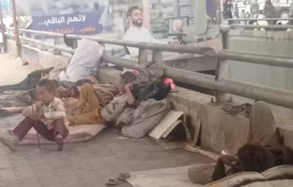 Aish Abdo (right) rests in the afternoon near one of his sons under the Bayt Baws Bridge in Sanaa, where the family has been living since their displacement from al-Hodeidah. [Yazan Abdul Aziz/Al-Fassel]