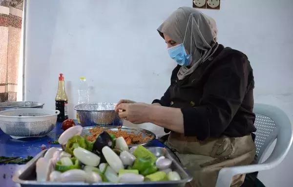 A woman prepares food inside the kitchen of the women-run catering service Taste of Mosul on September 13. [Zaid al-Obeidi/AFP]