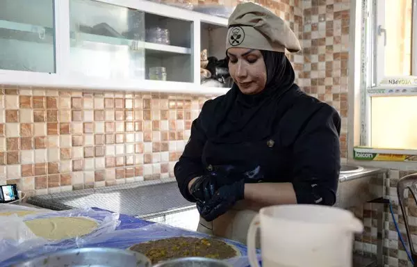 Abir Jassem prepares food inside the kitchen of the women-run catering service Taste of Mosul on September 13. [Zaid al-Obeidi/AFP]