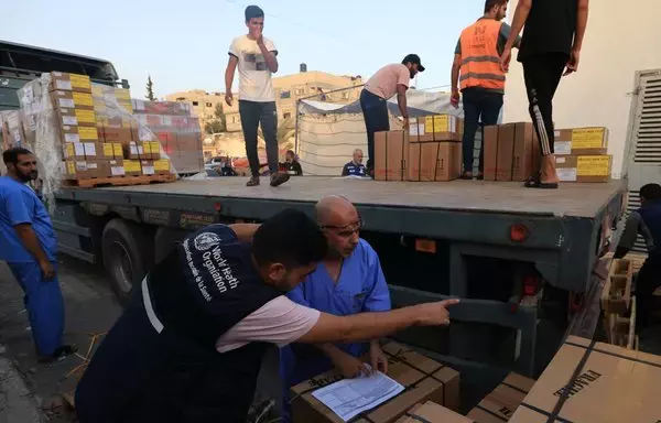 Workers unload medical aid from the World Health Organization at the Nasser hospital in Khan Yunis in the southern Gaza strip on October 23. An aid convoy entered the besieged Gaza strip that day, via the Rafah border crossing, the third since war erupted on October 7. [Mahmud Hams/AFP]