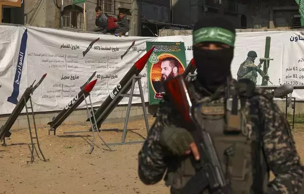 Children watch as the Palestinian Hamas movement displays rockets and a military drone during an exhibition organised by the Ezzedine al-Qassam Brigades, Hamas' military wing, on the occasion of the 35th anniversary of the establishment of the militant organisation, in the Jabalia refugee camp in northern Gaza strip on December 9. [Mohammed Abed/AFP]