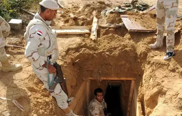 Egyptian soldiers inspect a smuggling tunnel in the border town of Rafah, along the border with the Hamas-run Gaza strip, on November 4, 2014. Such tunnels are often used for smuggling weapons and militants between Gaza and Egypt. [Mohamed el-Sherbeny/AFP]