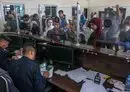 
Palestinian border guards check the documents of people leaving Gaza as dual national Palestinians and foreigners prepare to cross the Rafah border point with Egypt on November 2. [Said Khatib/AFP]        