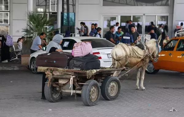 Civilians arrive in a donkey-drawn cart as dual national Palestinians and foreigners prepare to cross the Rafah border point with Egypt on November 2. [Said Khatib/AFP]