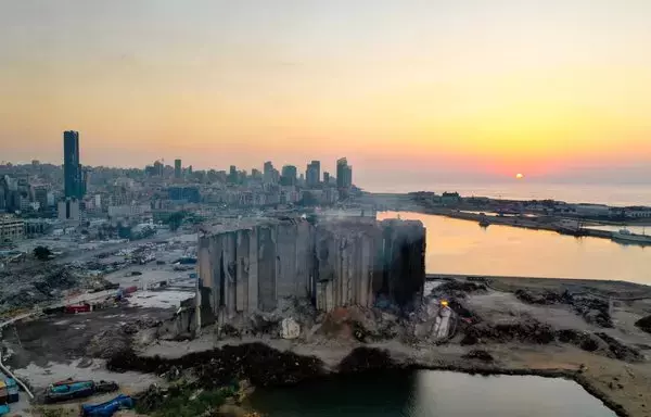 This aerial view shows the damaged grain silos at the port of the Lebanese capital Beirut, on August 3, 2022, following a partial collapse due to an ongoing fire. Two years prior, the port's massive explosion that many attributed to Hizbullah's negligence killed more than 200 people and devastated a huge section of the city.[AFP]