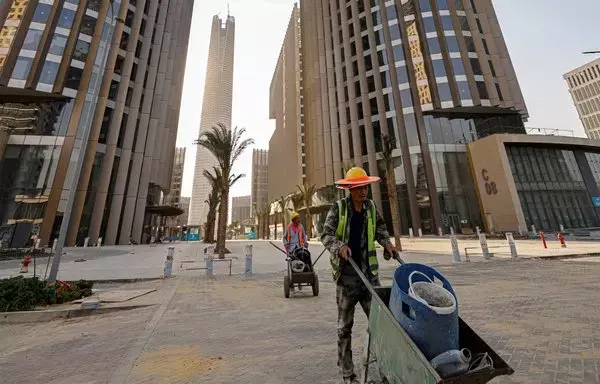 Chinese construction workers push carts at the site of ongoing work at the business and finance district, currently under construction, in Egypt's New Administrative Capital east of Cairo on August 1. [Khaled Desouki/AFP]