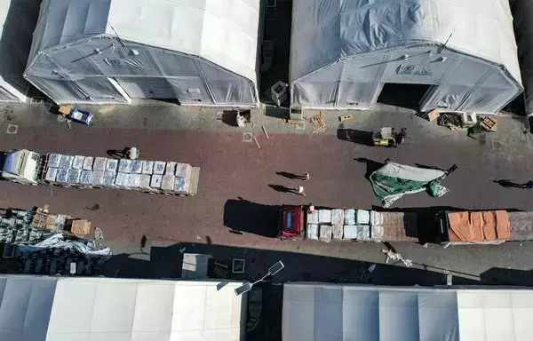 This aerial view shows humanitarian aid trucks arriving from Egypt at a storage facility in Khan Yunis in the southern Gaza strip on October 21. [Belal Al Sabbagh/AFP]