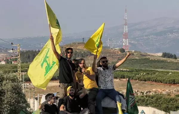 Supporters of Lebanese Hizbullah and the Amal movement gather for a rally in Lebanon's southern town of Kfar Kila on May 25, 2022. Amid the ongoing Israel-Hamas war, Iran and its allied militias, including Hizbullah, have been ramping up recruitment in southern Syria and southern Lebanon. [Mahmoud Zayyat/AFP]