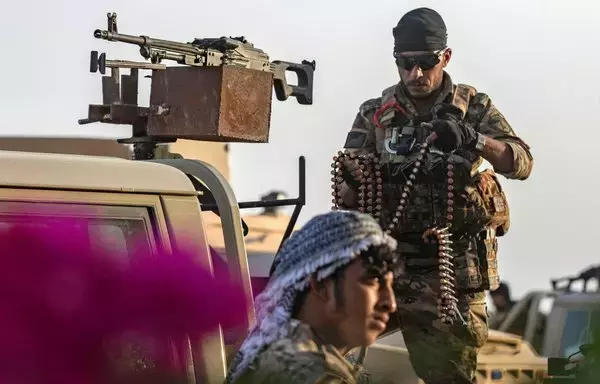 A member of the Syrian Democratic Forces loads a machine gun belt on his vehicle in al-Busayrah, Deir Ezzor province, on September 4. [Delil Souleiman/AFP]