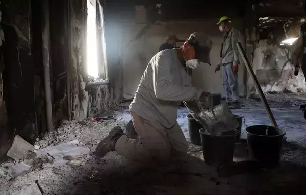 Archaeologists from the Israel Antiquities Authority collect ashes from a burnt out house inside Kibbutz Nir Oz in southern Israel on November 9, to identify residents who went missing during the October 7 terrorist attack. [Gil Cohen-Magen/AFP]