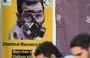 
A poster depicting Syria's president Bashar al-Assad in a gas mask is seen in the opposition-held northern city of Afrin on August 20, marking the 10-year anniversary of chemical attacks that killed over 1,400 people in Eastern Ghouta, outside Damascus. [Rami al-Sayed/AFP]        