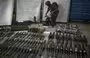 
An Israeli soldier stands with weapons recovered from areas Hamas targeted in its October 7 terrorist attack on southern Israel, on October 26. [Aris Messinis/AFP]        