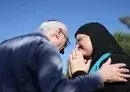 
Nir (L), the brother of killed Israeli-Canadian peace activist Vivian Silver, greets Arab-Israeli Ghadir Hani, a fellow peace activist from Acre, during a memorial service for Silver in Kibbutz Gezer, in central Israel on November 16. [Oren Ziv/AFP]        