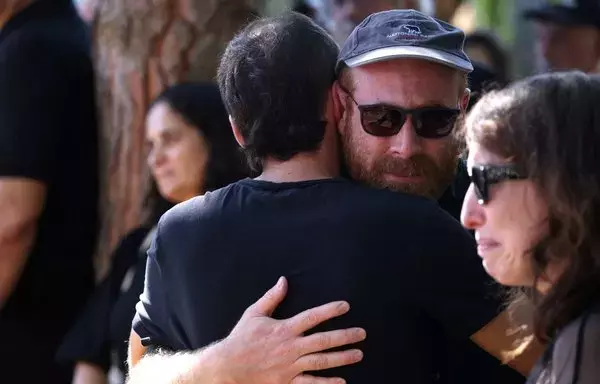 Mourners grieve as they gather for the memorial of 74-year-old Israeli-Canadian peace activist Vivian Silver, in Kibbutz Gezer in central Israel on November 16. [Oren Ziv/AFP]