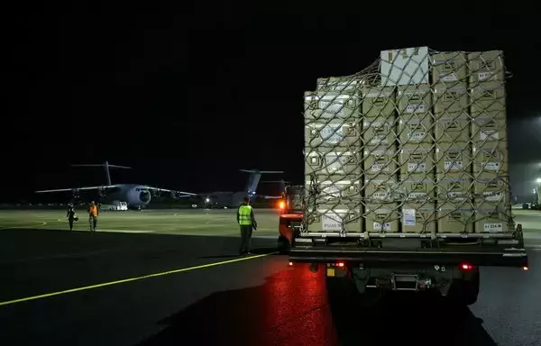 French air force soldiers arrive to load boxes of humanitarian aid bound for Gaza into a French cargo Airbus A400M, heading to Egypt at the Bricy Air Base, a French Air and Space Force base near Orleans, on November 20. [Thomas Samson/AFP]