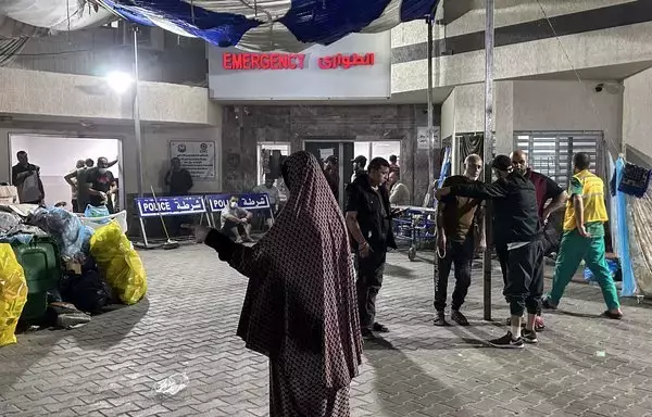 People stand outside the emergency ward of Al-Shifa hospital in Gaza City on November 10, amid ongoing battles between Israel and Hamas. Israel's military on Sunday released security camera footage it said showed hostages being brought into the hospital on October 7. [AFP]