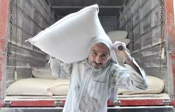 A worker at a flour warehouse in Beirut supplies a bakery with bags of flour before the stock dwindles. [Ziyad Hatem/Al- Fassel]