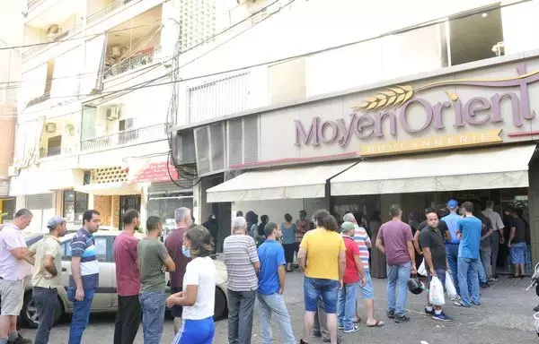 People wait in line outside the Middle East Bakery in the Jdeideh area of Mount Lebanon to purchase bread. [Ziyad Hatem/Al-Fassel]