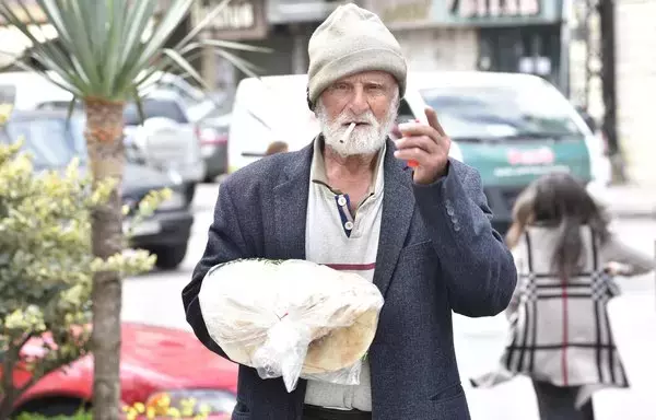 A man holds a bundle of bread purchased from a bakery in the Jdeideh area of Mount Lebanon. [Ziyad Hatem/Al-Fassel]