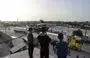 
Young boys look at trucks carrying humanitarian aid entering Gaza via the Rafah crossing with Egypt on November 26, the third day of a truce between Israel and Hamas. [Mohammed Abed/AFP]        