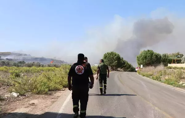 Lebanese civil defense volunteers walk towards a forest fire that reportedly ignited after shelling from Israel in Alma al-Shaab, close to south Lebanon's border with Israel on October 26, amid the ongoing battles between Israel and Hamas in the Gaza strip. [AFP]