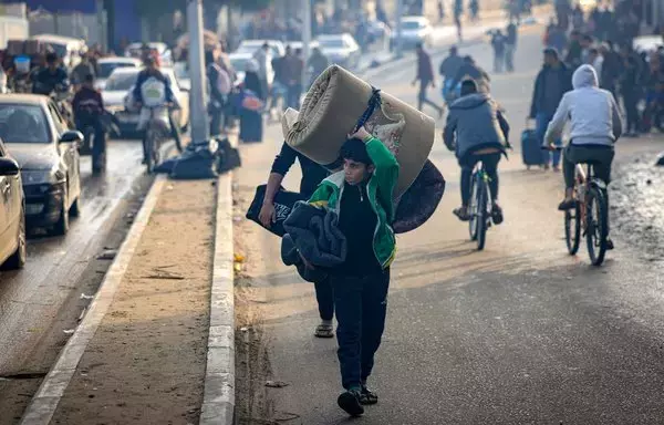 فلسطينيون يحملون بعض أمتعتهم أثناء توجههم إلى مناطق أكثر أمانا عقب استئناف الغارات الإسرائيلية على رفح في جنوب قطاع عزة في 1 كانون الأول/ديسمبر، بعد انتهاء هدنة مدتها 7 أيام بين إسرائيل وحماس. [محمود الهمص/وكالة الصحافة الفرنسية]