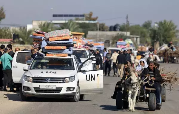 United Nations employees and Palestinian civilians flee Khan Yunis in the southern Gaza strip as battles between Israel and Hamas militants continue on December 3. [Mahmud Hams/AFP]