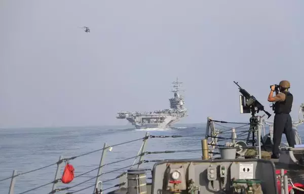 The aircraft carrier USS Dwight D. Eisenhower, guided-missile cruiser USS Philippine Sea, guided-missile destroyers USS Gravely and USS Stethem, and French Navy destroyer FS Languedoc transit the Strait of Hormuz, with air support from a French Navy E-2C Hawkeye and Air Force Rafale strike aircraft, November 26. [US Navy]