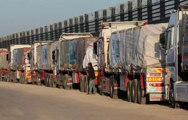 Trucks with humanitarian aid wait on th Egyptian side of the Rafah crossing with Gaza on December 11. Israel on December 12 announced an additional checkpoint for examining relief supplies before dispatching them to Gaza via the Rafah crossing. [Giuseppe Cacace/AFP]