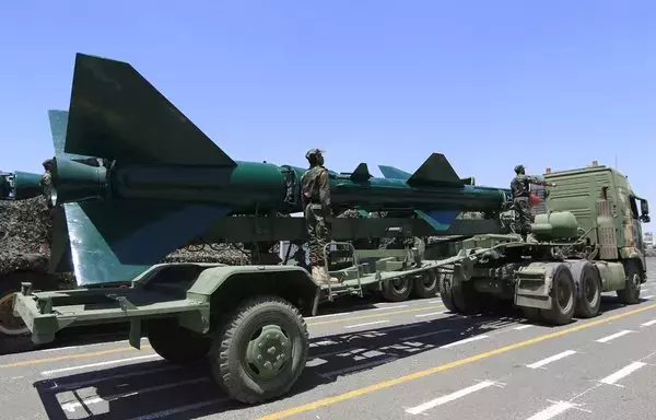 Houthi fighters stand on a missile carrier during a September 21 military parade in Sanaa. [Mohammed Huwais/AFP]