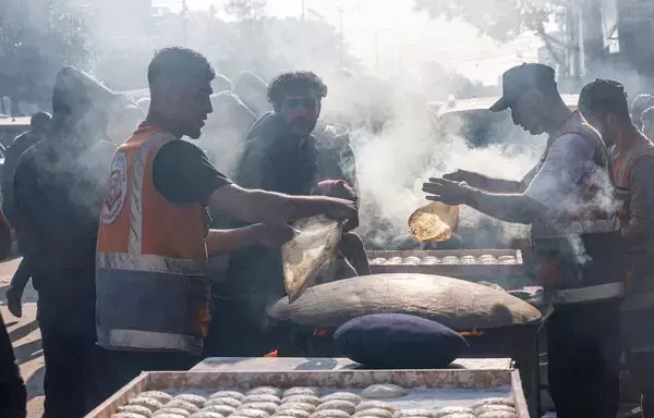 Palestinians prepare traditional unleavened bread in Rafah in the southern Gaza strip on December 18 amid continuing battles between Israel and the terrorist group Hamas. [Mohammed Abed/AFP]