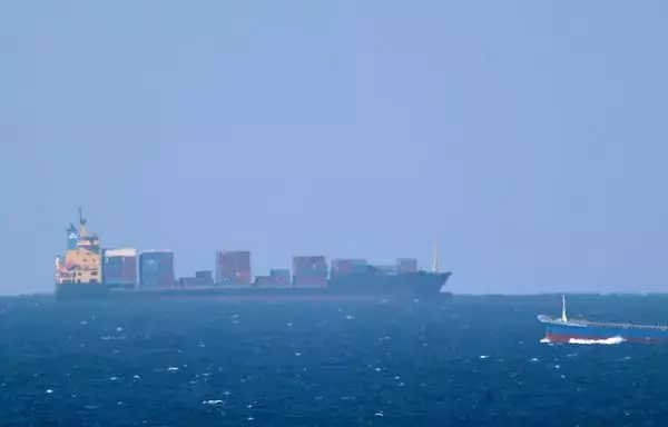 A cargo ship cruises toward the Strait of Hormuz off the shores of Khasab in Oman on January 15, 2012, after Iran threatened to close the Strait of Hormuz, cutting off the transport of 20% of the world's oil. [Marwan Naamani/AFP]