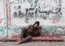 
A Palestinian man listens to his radio in a refugee camp in Rafah in the southern Gaza strip on December 17, amid continuing battles between Israel and Hamas. In the Gaza strip, it is now impossible to plug in computers or television sets, recharge phones or access the internet without generators or solar panels, a luxury few Gazans can afford. [Mohammed Abed/AFP]        