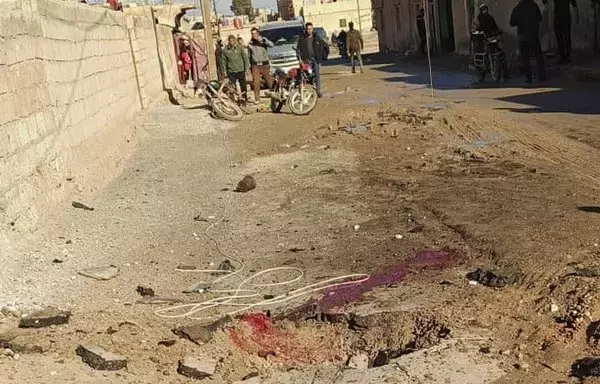 Local residents look on at the damage and blood on the street following a rocket attack by Iran-backed militants in al-Shaddadi, Syria, on December 26. [File]