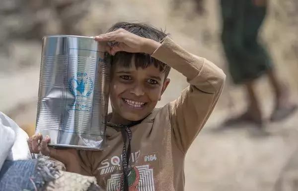 Displaced Yemenis receive humanitarian aid provided by the World Food Program in the city of Taez on September 11. [Ahmad al-Basha/AFP]