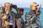 
Brig. Gen. Tariq Muhammad Abdullah Saleh, member of the Presidential Command Council in Yemen's internationally recognized government, looks through binoculars as he observes coastguard members patrolling in the Red Sea off the town of Mokha in Taez province, near the strategic Bab al-Mandeb strait, on December 12. [Khaled Ziad/AFP]        