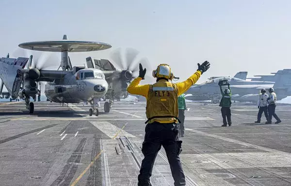 A sailor guides an E-2C Hawkeye during flight operations aboard the aircraft carrier USS Dwight D. Eisenhower in the Red Sea on November 5, 2023. [Pentagon]