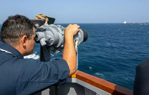 In support of Operation Prosperity Guardian, a sailor aboard guided-missile destroyer USS Mason uses high-powered binoculars to keep an eye on shipping in the Red Sea. [CMF]