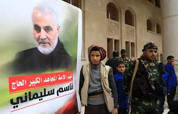 Supporters of the Houthis attend a vigil commemorating the second anniversary of the killing in Iraq of top Iranian commander Qassem Soleimani (portrait) in Sanaa on January 3, 2022. [Mohammed Huwais/AFP]