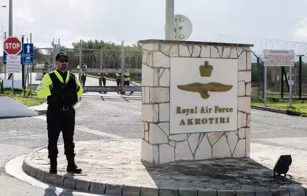 Police officers stand guard at the gates of the Royal Air Force Akrotiri base, a British overseas facility near the Cypriot city of Limassol, on January 14. [Iakovos Hatzistavrou/AFP]